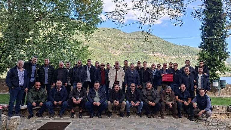 Ομαδική φωτογραφία πολλών ατόμων σε πάρκο, με βουνό στο βάθος.